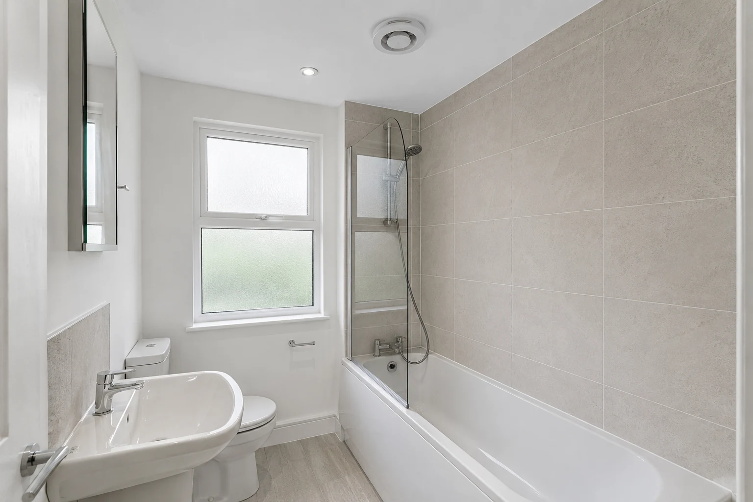 A clean, well-maintained rental bathroom in London with a compliant extractor fan and modern sanitaryware