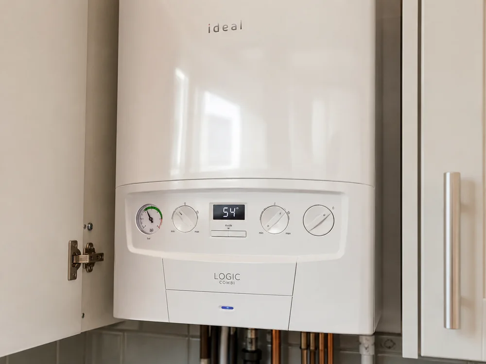 Newly serviced combi boiler in a London kitchen cupboard with pressure gauge reading correctly after completion